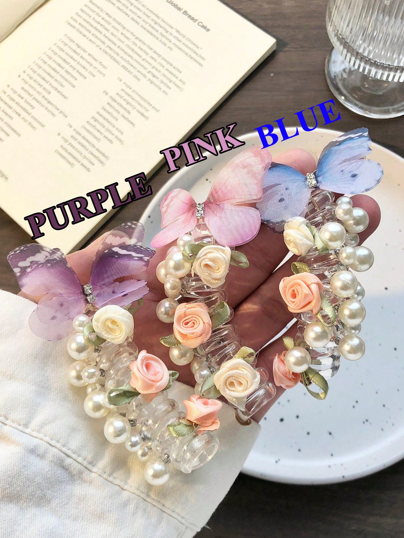Decorative hair clip with flowers and butterflies on a plate, with text 'Purple Pink Blue' overlay.