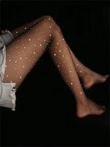 Black fishnet tights embellished with scattered rhinestones, worn by a model against a solid black background.