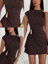 Brown dress with gold accents worn by a model on a white background