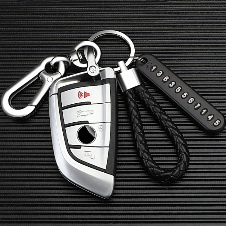 Car key fob with leather strap and carabiner on a textured black background