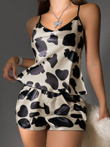 Woman wearing a cow print pajama set against a gray background