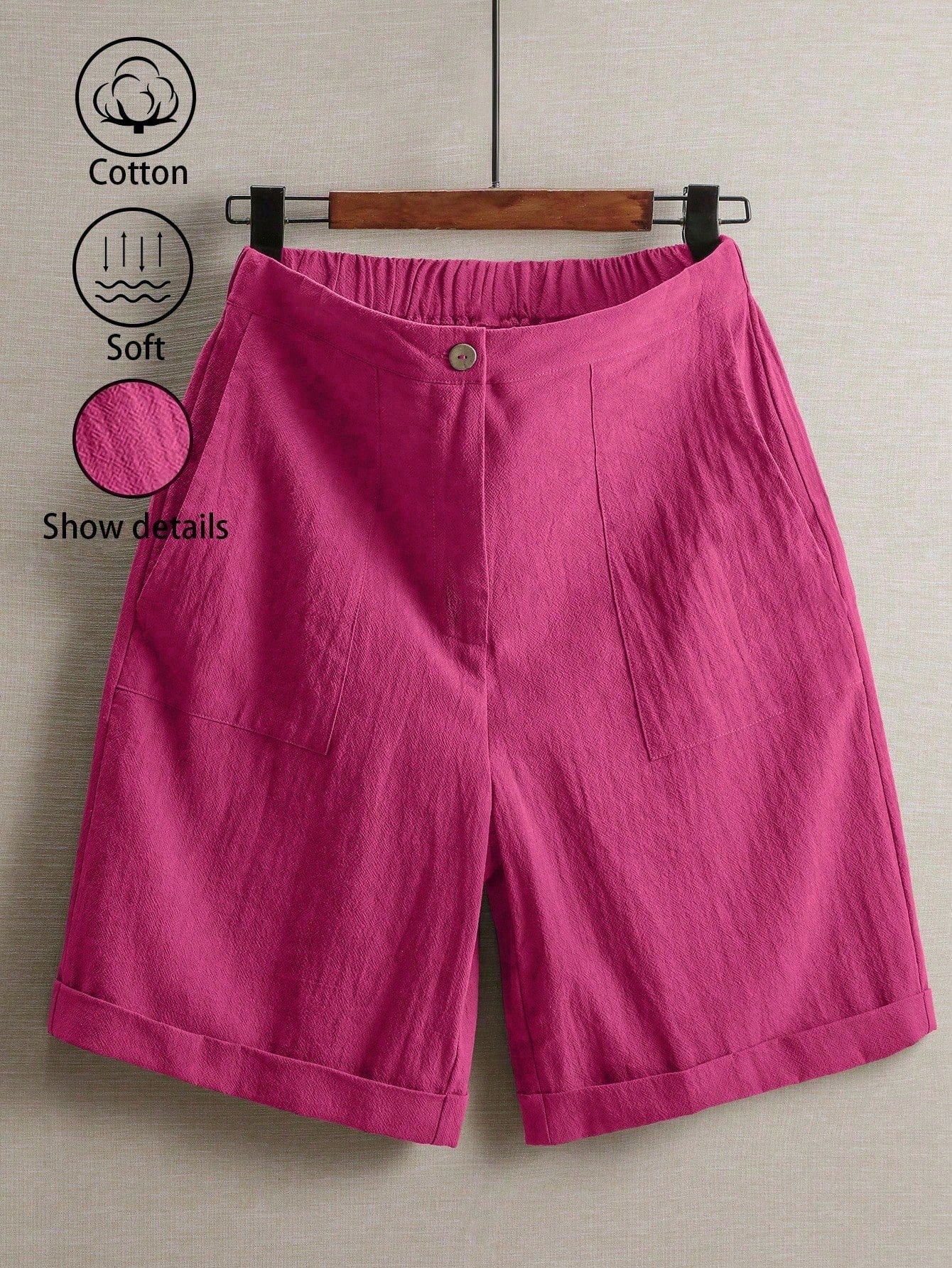 Pink shorts on a hanger with cotton and softness icons.