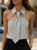 Woman wearing a white and black striped halter top with a tie detail.