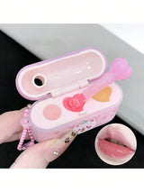 Pink lip gloss case with applicator and mirror, held by a hand.