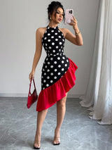 Woman taking a mirror selfie wearing a black and white polka dot dress with a red bottom half.