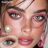 Advertisement for FreshLADY contact lenses with a close-up of a woman's face and inset showing Emerald Green lenses.