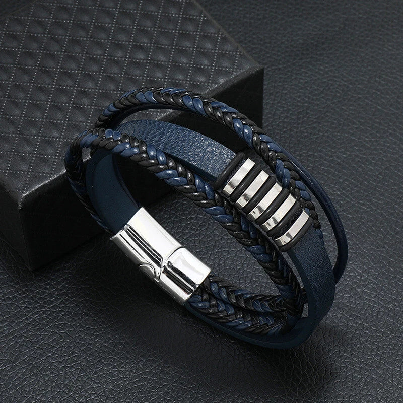 Blue braided leather bracelet with silver accents on a dark textured surface