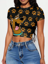 Person wearing a black crop top with cartoon character and paw prints, paired with blue jeans.
