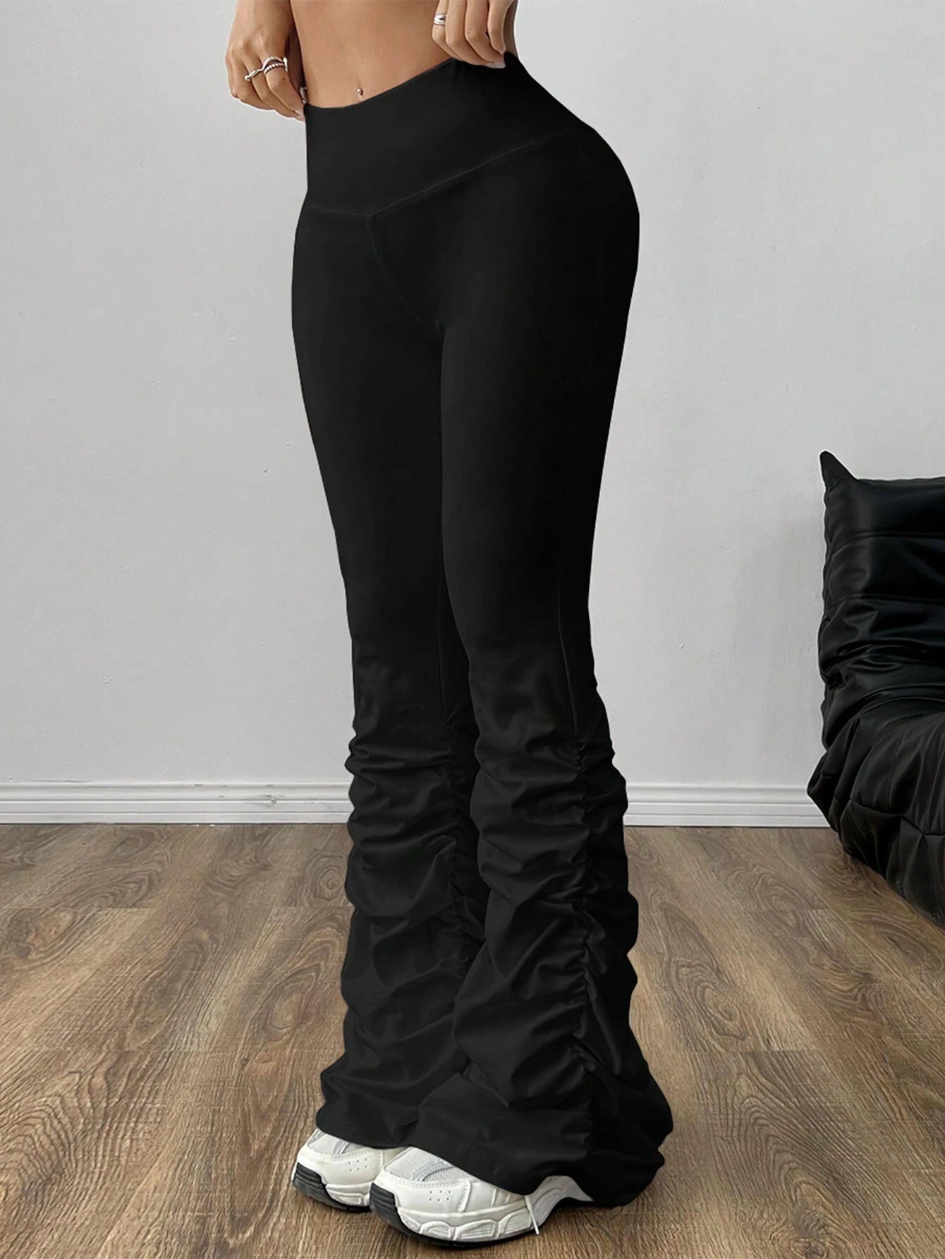 Black wide-leg pants worn by a person on a wooden floor with a neutral background