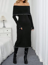 A woman models a black off-the-shoulder long-sleeve midi dress with white scalloped trim, paired with black knee-high boots, standing in a bedroom setting with white curtains and a bed.