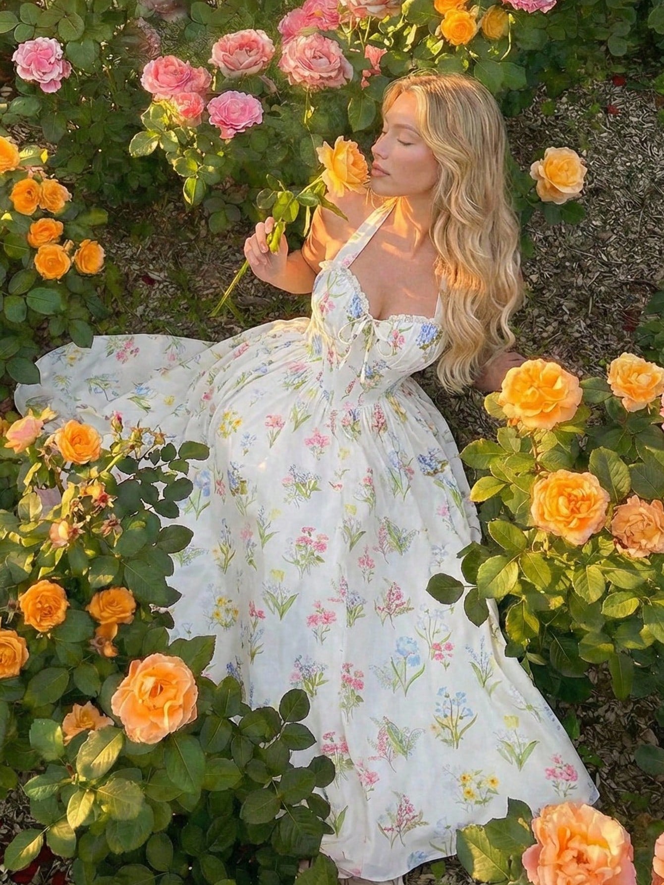 Woman in a floral dress surrounded by flowers in a garden