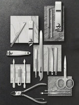 Collection of nail care tools on a dark surface with marble accents