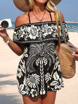 Woman in a black and white floral dress on a beach