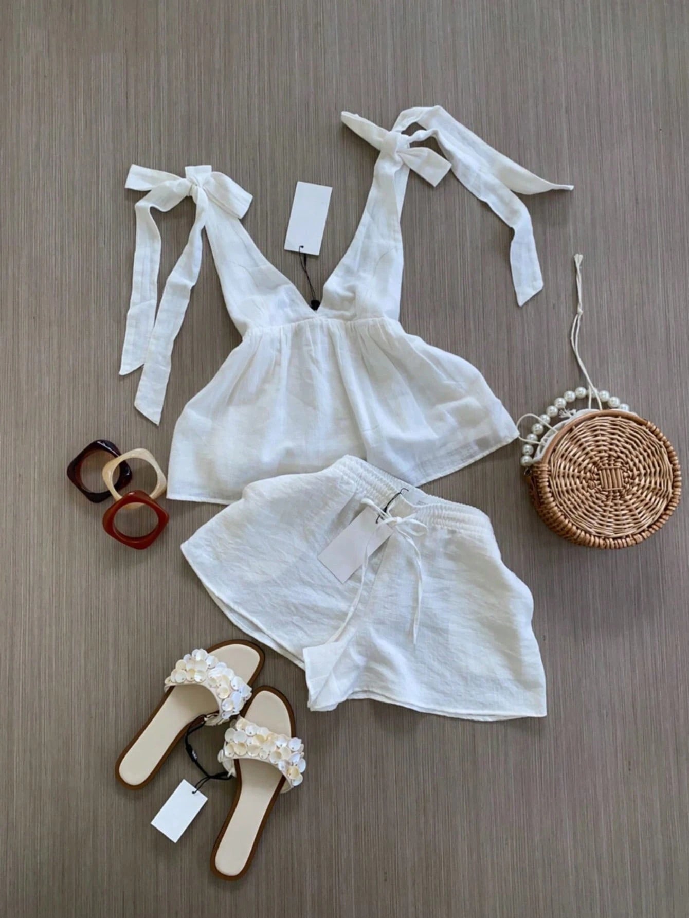 White lace top and shorts with accessories on a wooden surface