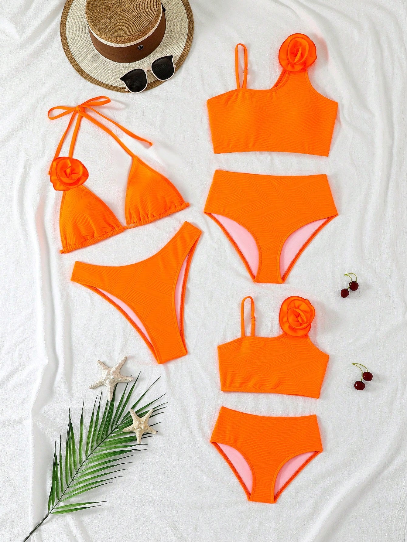 Orange bikini set with matching top and bottom on a white surface with decorative items.