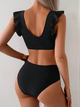 Black bikini set with ruffled straps on a plain background