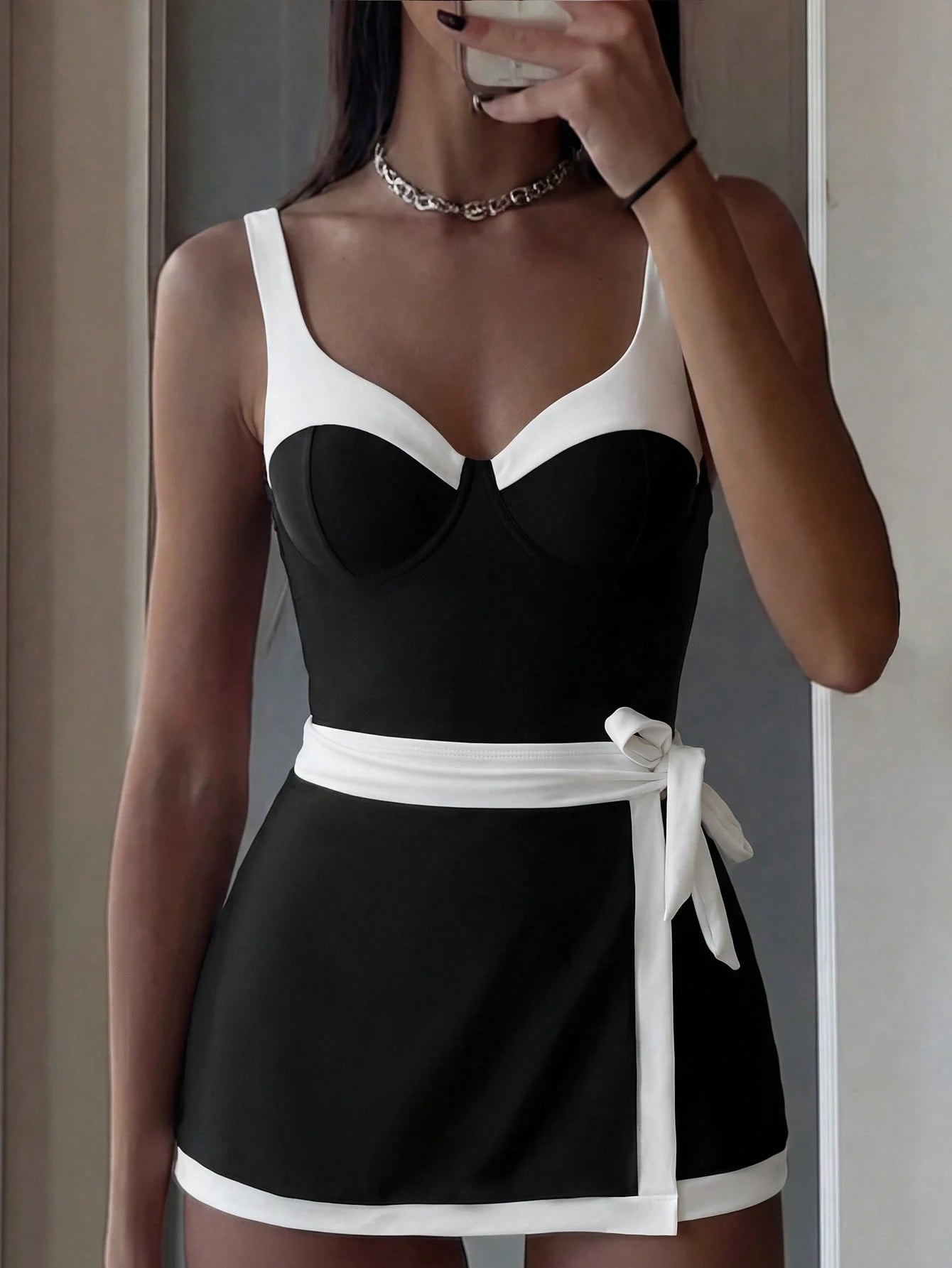 Black and white dress worn by a person taking a mirror selfie.