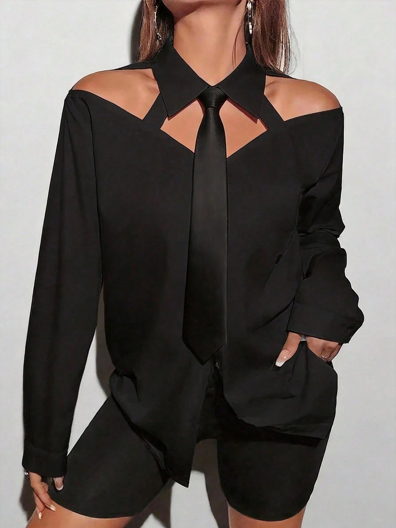 Black outfit with cut-out design on a plain background