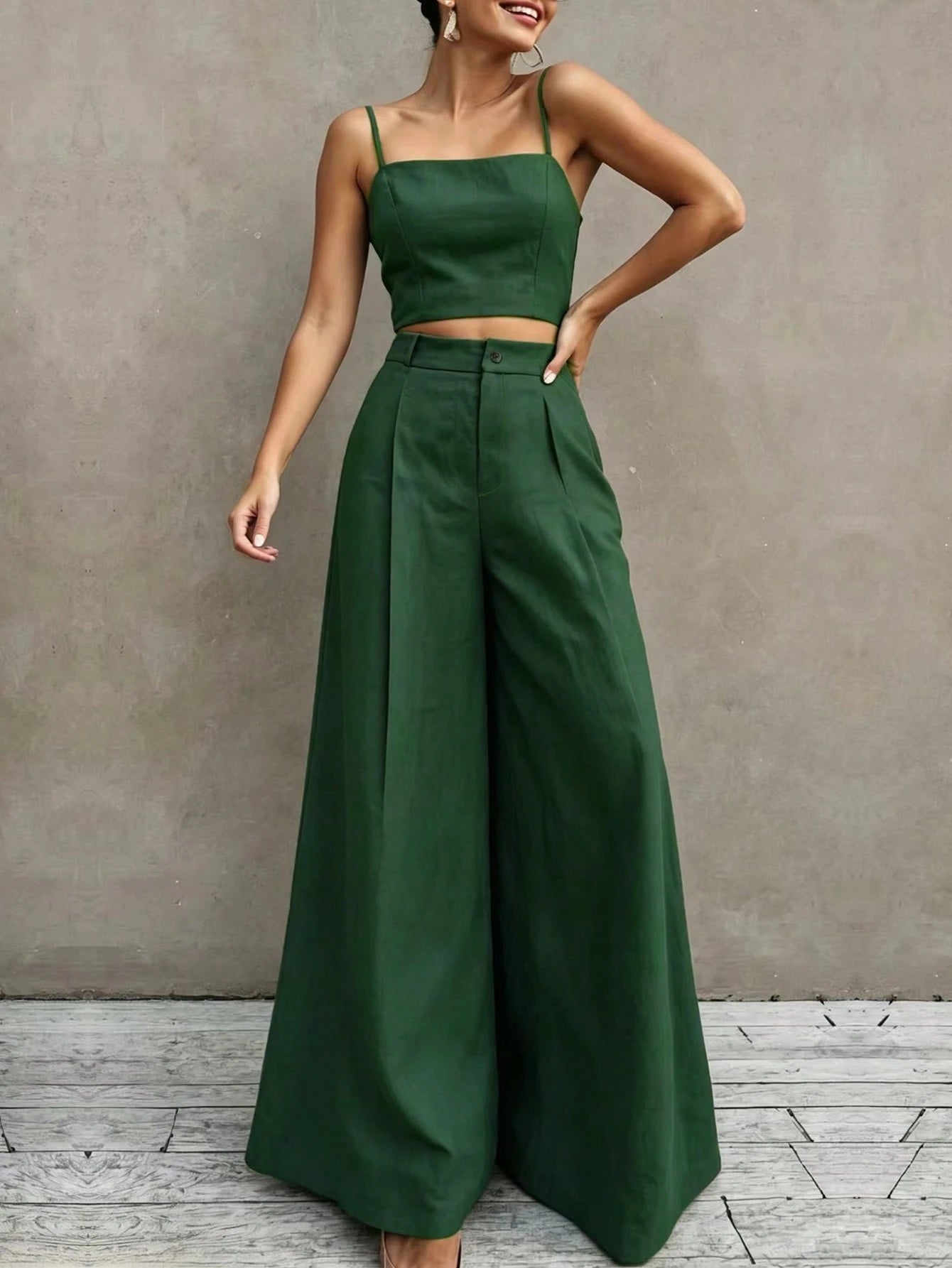 Woman wearing a green two-piece outfit against a gray background