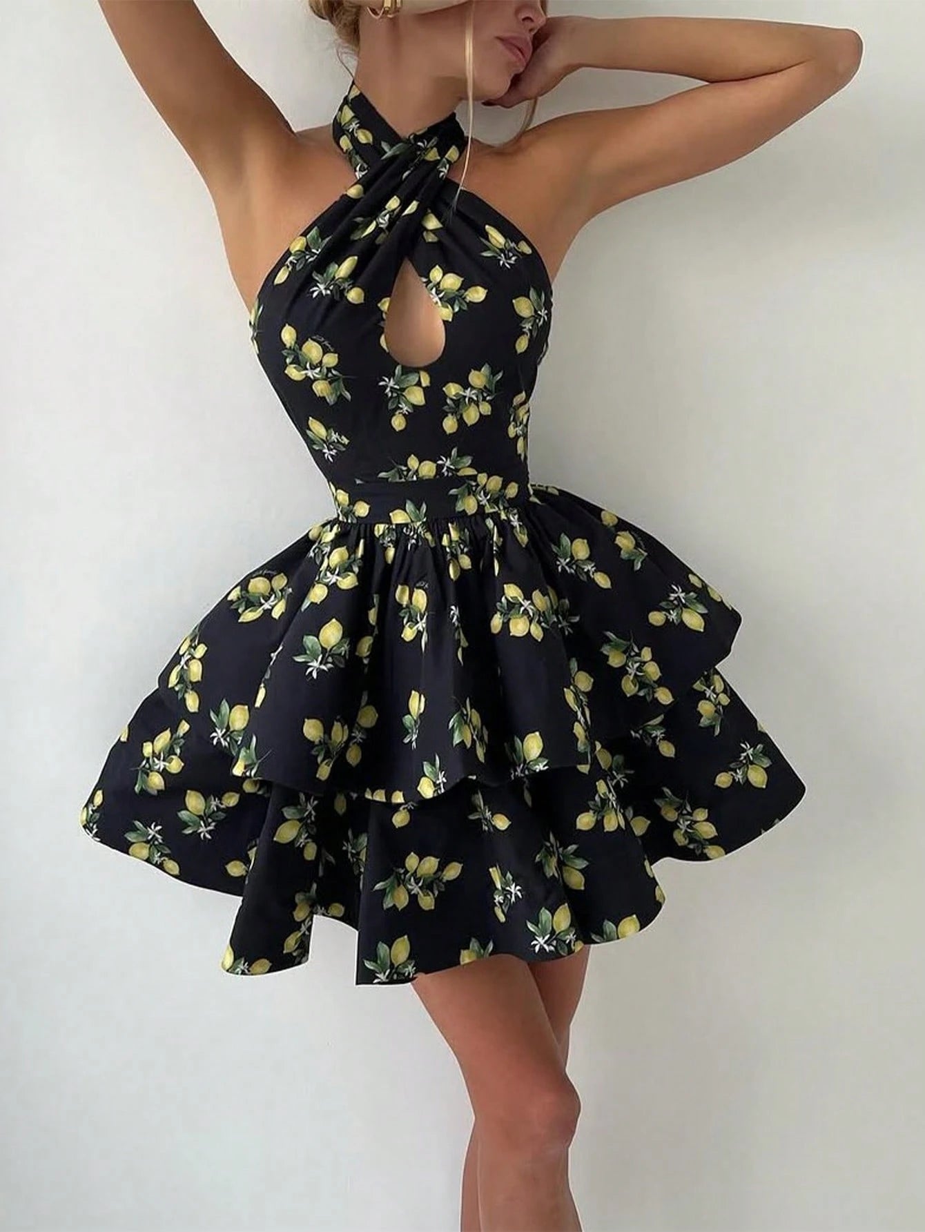 Black dress with lemon print worn by a model on a white background