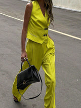 Person wearing a bright yellow outfit with a black handbag on a street.