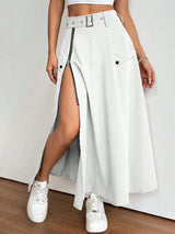 Person wearing a white skirt with a high slit and white sneakers on a plain background